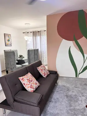 a living room with a couch and a painting on the wall at Apartment near the airport in Boca Chica