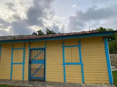 a yellow and blue building with two windows at the Count of Villa Rosa in La Ceiba