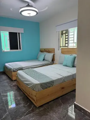 two beds in a room with blue walls at Villa yaya 1 in Boca Chica