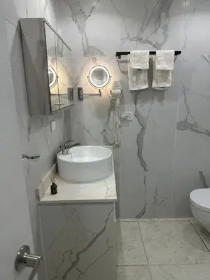 a white bathroom with a sink and a mirror at Beachfront - Stunning View in Boca Chica