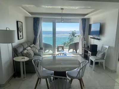 a living room with a table and a view of the ocean at Beachfront - Stunning View in Boca Chica