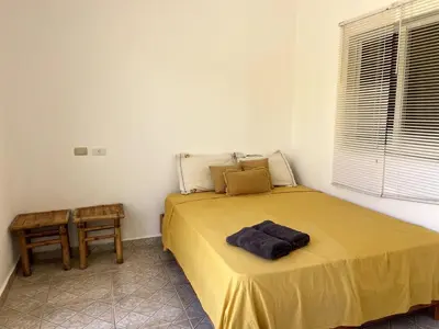 a bedroom with a bed with a yellow blanket on it at Casa La Loma En Las Galeras in Colorado