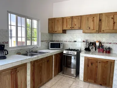 a kitchen with wooden cabinets and stainless steel appliances at Casa La Loma En Las Galeras in Colorado