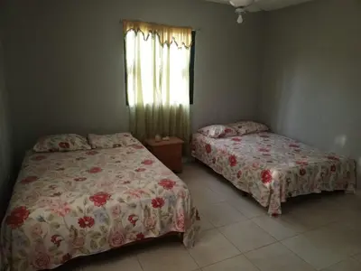 a bedroom with two beds and a window at Casa Ramona in Las Galeras