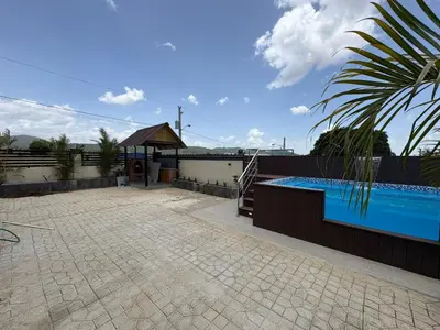 a swimming pool with a gazebo next to a house at Villa Sol Odalis in Jarabacoa