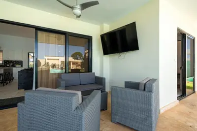 a living room with two chairs and a flat screen tv at Peace Design Exclusivity in Sosúa