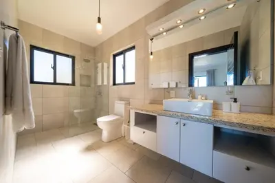 a bathroom with a sink and a toilet and a mirror at Peace Design Exclusivity in Sosúa