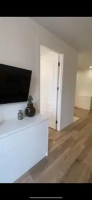 a white living room with a tv on a white wall at Sirius apartment in Santo Domingo