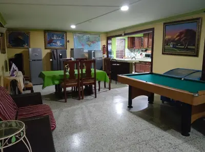 a living room with a pool table and a kitchen at Apart-Hotel Costa Verde in Costa Verde
