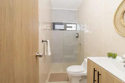 a bathroom with a shower and a toilet and a sink at Chic Bayahibe 2BR in Sunshine near Bayahibe Center in Bayahibe