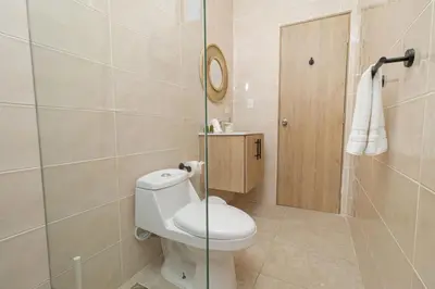 a bathroom with a toilet and a glass shower at Chic Bayahibe 2BR in Sunshine near Bayahibe Center in Bayahibe