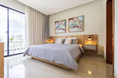 a bedroom with a large bed and a large window at 2BR Tropical Escape - Private Terrace, BBQ, Pool, Walk to Beach in Punta Cana