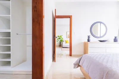 a bedroom with a bed and a mirror at 2BR Tropical Escape - Private Terrace, BBQ, Pool, Walk to Beach in Punta Cana