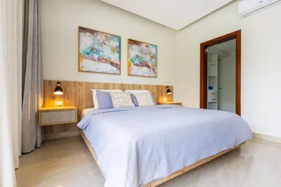 a bedroom with a large bed and two pictures on the wall at 2BR Tropical Escape - Private Terrace, BBQ, Pool, Walk to Beach in Punta Cana