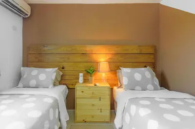 a bedroom with two beds and a wooden headboard at Resort Villas | 2 hab con piscina y playa in Juan Dolio