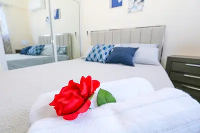 a red rose sitting on top of a white bed at Edificio Amber in San Cristóbal