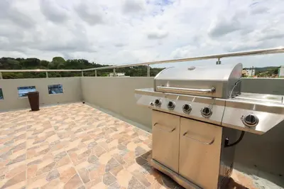 an outdoor kitchen with a grill on a balcony at Edificio Amber in San Cristóbal