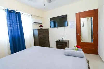 a bedroom with a bed and a dresser and a mirror at Edificio Amber in San Cristóbal