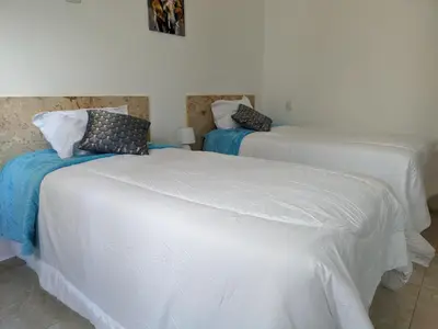 a bedroom with two beds with white sheets at Azure Breeze Hotel in Bayahibe