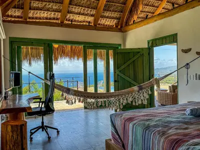 a bedroom with a bed and a view of the ocean at AguaSanta, Breeze & Views in Palmarito