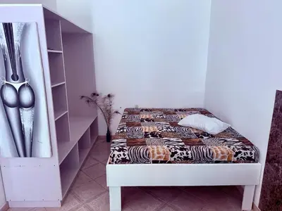 a bedroom with a bed and a shelf with utensils at CasaLoca Cabarete Studio Apartment in Cabarete