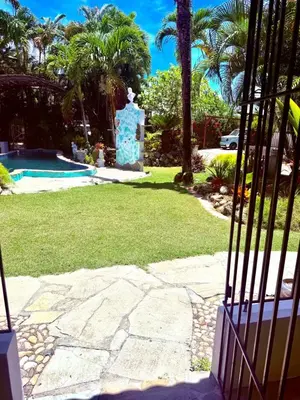 a statue in a yard next to a swimming pool at CasaLoca Cabarete Studio Apartment in Cabarete