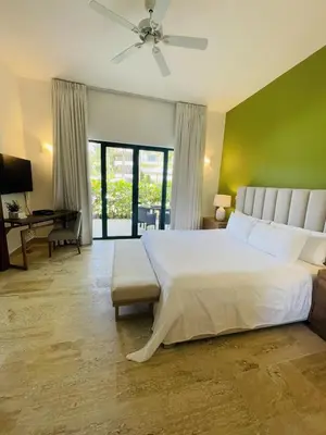 a bedroom with a white bed and a green wall at Stylish 1BR, Pools & Walk to Beach - Sublime in Las Terrenas
