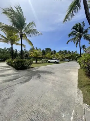 a car parked in a parking lot with palm trees at Stylish 1BR, Pools & Walk to Beach - Sublime in Las Terrenas