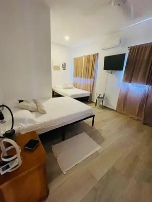 a room with two beds and a flat screen tv at 2BR Getaway Villa in Montecristi in San Fernando de Monte Cristi