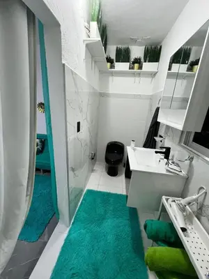 a bathroom with a white sink and a green rug at Villa Medrano Home in Punta Cana