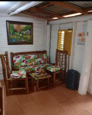 a porch with a couch and two chairs and a table at Las Amapolas, Saman typical houses in Las Galeras
