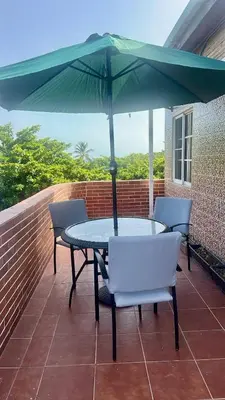 a table and chairs with an umbrella on a patio at Sea Near and Beach a few minutes walking Top Location by RHV Living in San Felipe de Puerto Plata