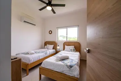 a bedroom with two beds and a window at Armonía Las Terrenas in Las Terrenas