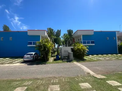 a blue building with a car parked in front of it at Bienvenue chez soi in Boca Chica