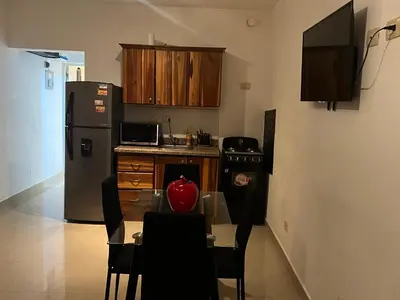 a small kitchen with a table and a refrigerator at Bienvenue chez soi in Boca Chica