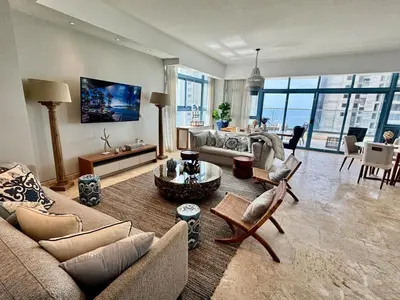 a living room with a couch and a table at Juan dolio Penthouse, beach access 3BR Salitre Tower front of Club Hemingway in Juan Dolio
