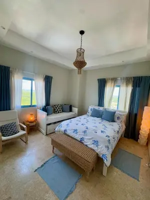 a bedroom with a bed and a couch and windows at Juan dolio Penthouse, beach access 3BR Salitre Tower front of Club Hemingway in Juan Dolio