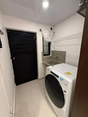 a washing machine in a room with a black door at Residenza in Santiago de los Caballeros