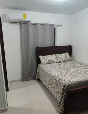 a bedroom with a bed with a brown head board at Habitación con baño privado y otras áreas compartidas in San Luis