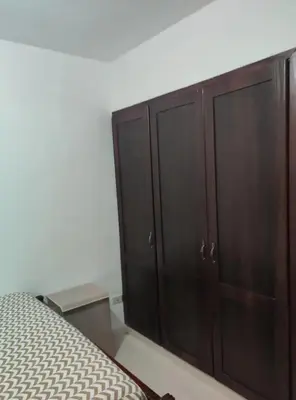 a bedroom with a bed and wooden cabinets at Habitación con baño privado y otras áreas compartidas in San Luis