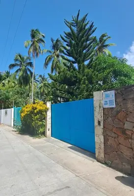 a blue fence with palm trees in the background at Beach Bungalow 100 m Playa Coson in Las Terrenas