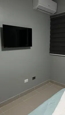 a bedroom with a flat screen tv on the wall at Moderno Apartamento Boca Chica, 5 minutos del Aeropuerto in La Caleta