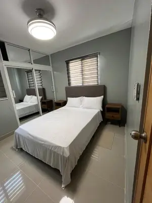 a bedroom with a large white bed and two mirrors at Moderno Apartamento Boca Chica, 5 minutos del Aeropuerto in La Caleta