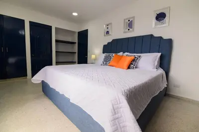 a bedroom with a large bed with an orange pillow at Casa Jobo Scenic ViewsPrivate Pool TablePool in San Felipe de Puerto Plata
