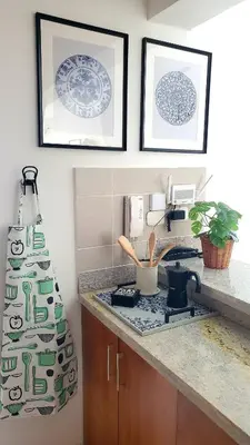 a kitchen with a stove and framed pictures on the wall at Backup Power 2BR 2BA AC WiFi Gym 24h Security Ideal for long stays in Santiago de los Caballeros