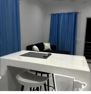 a white counter top with two stools and a table at Casi de Aleyda in Las Terrenas