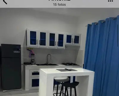 a kitchen with a black refrigerator and a counter with stools at Casi de Aleyda in Las Terrenas