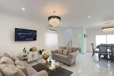 a living room with a couch and a dining room at Elegante Casa Estrella Marina 117 Pool BBQ in La Romana