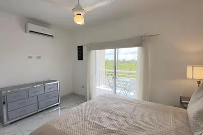 a bedroom with a bed and a window with a balcony at Elegante Casa Estrella Marina 117 Pool BBQ in La Romana