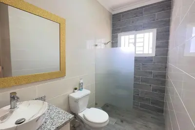 a bathroom with a toilet and a sink and a mirror at Elegante Casa Estrella Marina 117 Pool BBQ in La Romana